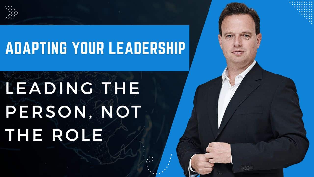 A man in a suit stands next to text that reads, "Adapting your leadership: Leading the person, not the role," on a blue and black background, inspired by One Minute Manager workshop principles.